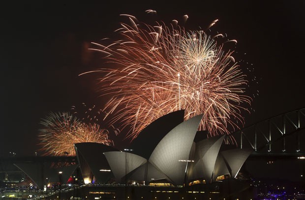 Fogos são vistos na Ópera House de Sydney na noite desta quarta-feira (31) – no horário local – como parte das celebrações de Ano Novo (Foto: Rob Griffith/AP)
