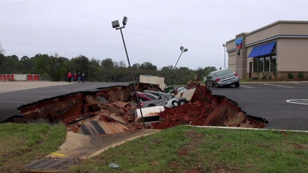 Uma imensa cratera se abriu no estacionamento de um restaurante e engoliu diversos carros nos Estados Unidos (Foto: BBC)