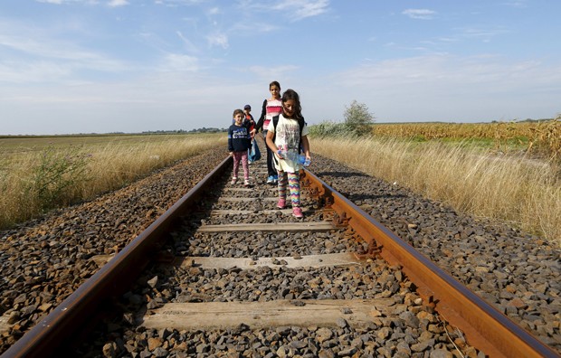 Migrantes sírios atravessam linha de trem na fronteira entre Hungria e Sérvia, próximo de Roszke (Hungria) (Foto: Laszlo Balogh/ Reuters)