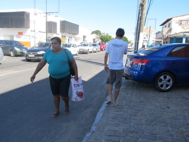 Pedestres são obrigados a ir para a rua por conta dos carroestacionados na calçada. (Foto: Fabiana de Mutiis/G1)