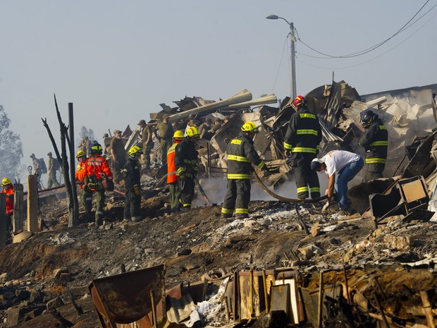 Onze helicópteros, seis aviões e 2 mil militares e policiais lutavam nesta segunda-feira (14) para controlar os focos do incêndio mais grave da história do porto chileno de Valparaíso, que matou 12 pessoas (Foto: Martin Bernetti/AFP)