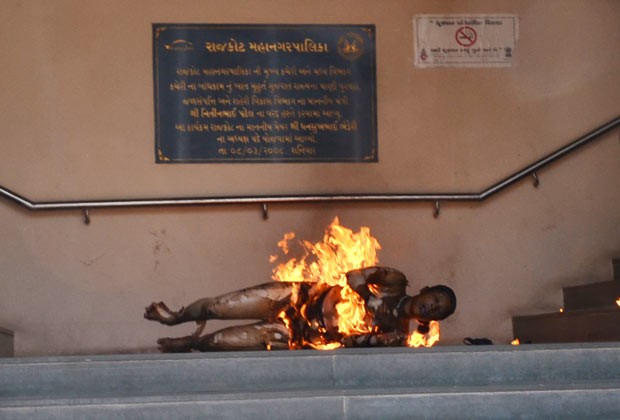 Indiano queima-se nesta quarta-feira (3) em Rajkot em protesto contra a destruição da casa de sua família (Foto: AFP)