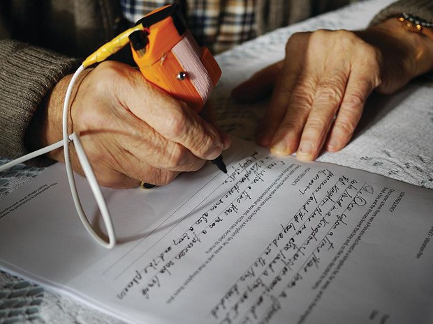 Paciente testa caneta desenvolvida para pessoas com Parkinson: micrografia faz letra ficar cada vez menor (Foto: Dopa Solution/Divulgação)