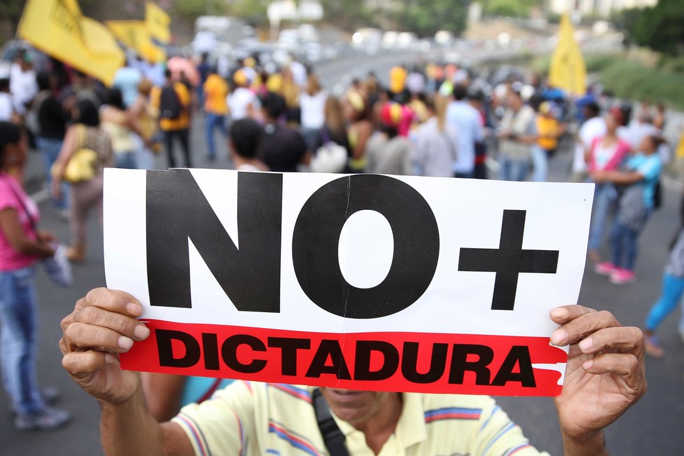 Manifestante leva cartaz com a mensagem ‘Não mais ditadura’ em protesto contra o presidente Nicolas Maduro, em uma rodovia de Caracas, nesta sexta-feira (31)  (Foto: Carlos Garcia Rawlins/ Reuters)