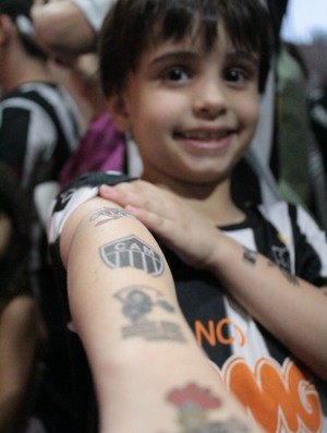 O pequeno Bruno mostra as 'tatuagens' no braço, que fez como promessa para o título do Galo (Foto: Maurício Paulucci / Globoesporte.com)