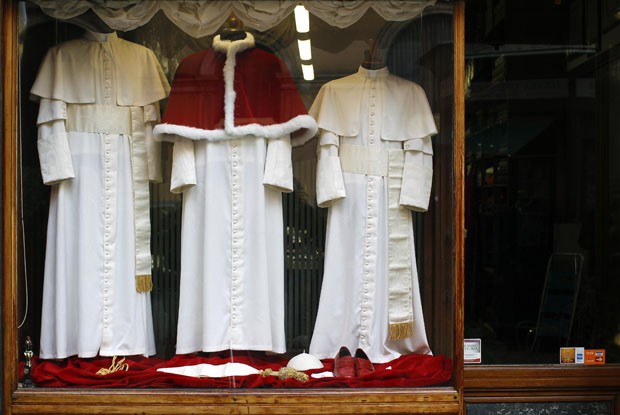 Os três tamanhos da veste do Papa estão em exibição na vitrine da alfaiataria (Foto: Alessandro Bianchi/Reuters)