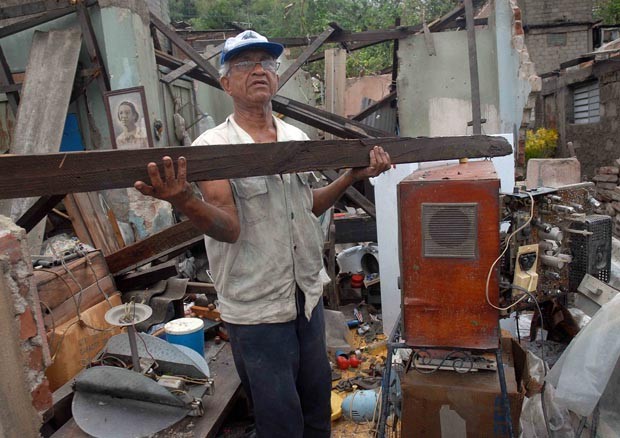 Homem recolhe pedaços de sua casa destruída em Santiago de Cuba (Foto: Ain-Miguel Rubiera Justiz/AFP)