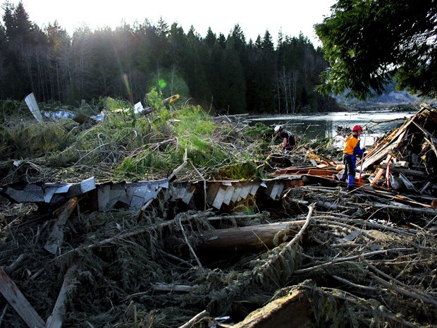 Equipes de resgate vasculham escombros em área atingida por um deslizamento de terra nos EUA. (Foto: Joshua Trujillo/Seattlepi.com/AP)