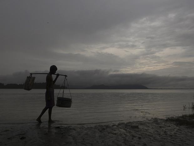 Homem caminha sob céu carregado de nuvens na época de chuvas de monções na índia (Foto: AP)