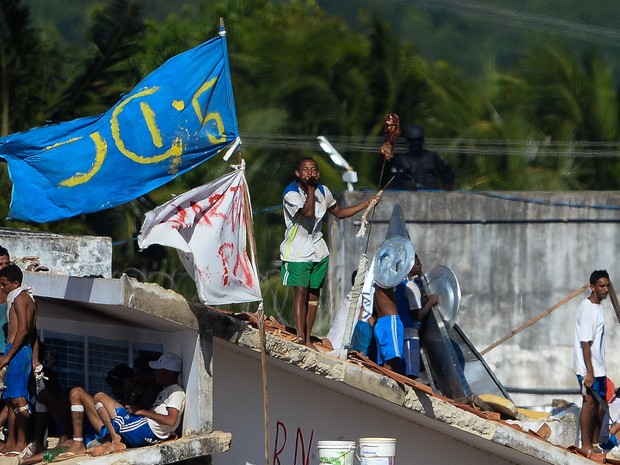 19/01 - Presos são vistos no telhado durante uma rebelião na penitenciária de Alcaçuz, perto de Natal, no Rio Grande do Norte (Foto: Andressa Anholete/AFP)