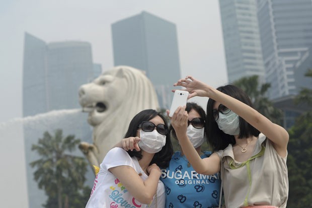 Moradores saem com máscaras em Cingapura (Foto: Joseph Nair/AP)