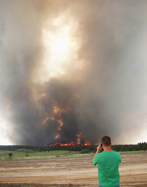 Morador fotografa o fogo destruindo árvores da Floresta Negra, em Colorado Springs, nesta quarta-feira (12) (Foto: Rick Wilking/Reuters)