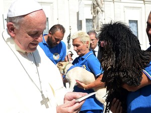 Papa Francisco se encontra com membros de uma unidade canina em sua audiência na Praça de São Pedro, no Vaticano. (Foto: Osservatore Romano/AFP)
