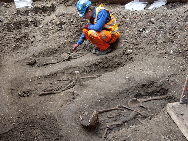 Arqueólogo faz medições de esqueleto encontrado no centro de Londres (Foto: Crossrail/AFP)