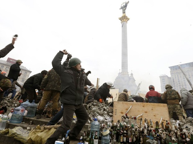 19/2 - Jovens atiram pedras contra a polícia, com diversas garrafas de coquetel molotov preparadas no chão, na Praça da Independência, em Kiev (Foto: Vasily Fedosenko/Reuters) 19/2 - Jovens atiram pedras contra a polícia, com diversas garrafas de coquetel molotov preparadas no chão, na Praça da Independência, em Kiev (Foto: Vasily Fedosenko/Reuters)