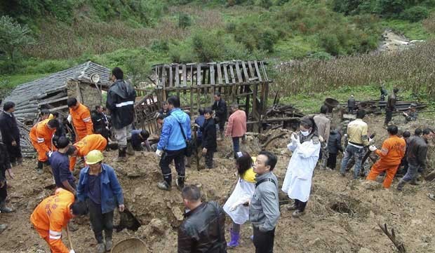 Familiares e equipe de resgate fazem busca após deslizamento de terra que cobriu de escombros uma escola na província sudoeste chinesa de Yunnan (Foto: Reuters)