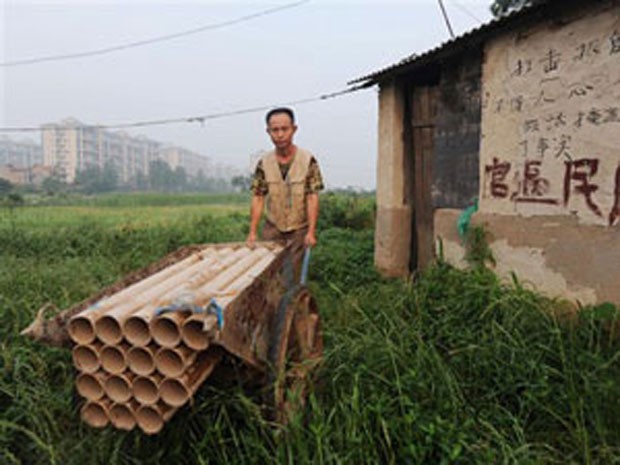 Um camponês chinês construiu um canhão caseiro com um carrinho de mão, encanamentos e fogos de artifício para afugentar as autoridades que querem expropriar suas terras na província de Hubei. (Foto: AFP)