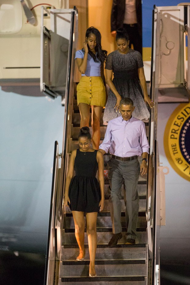 Barack Obama e sua família desembarcam do avião presidencial ao chegar ao Havaí neste sábado (19) (Foto: Marco Garcia/AP)