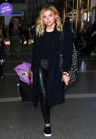 Look do dia: Chloë Moretz aposta em calça de couro com tênis para viajar