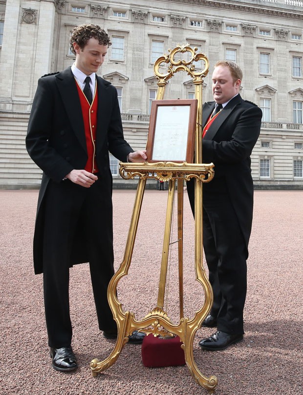 Cavalete com anúncio do nascimento da nova princesa britânica é colocado em frente ao palácio de Buckingham neste sábado (2) (Foto: Steve Parsons/Pool via AP)