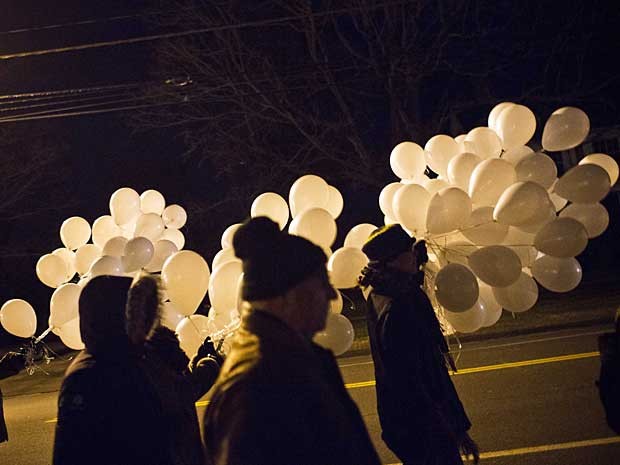 Moradores carregam balões durante marcha pela paz na noite deste sábado (22), em homenagem aos 26 que morreram - 20 crianças e seis adultos - na escola Sandy Hook, em Newtown, Connecticut, pelos disparos de Adam Lanza. O ataque ocorreu na sexta-feira (14). (Foto: Andrew Burton / Reuters)