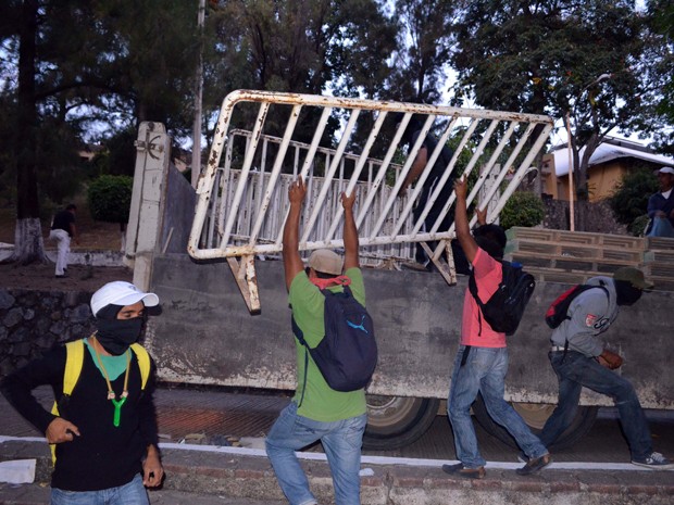 Manifestantes derrubam barreiras colocadas pela polícia para conter protestos em Chilpacingo, no domingo (14) (Foto: AP Photo/Alejandrino Gonzalez)