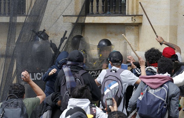 Polícia de choque são encurralados por manifestantes com pau e pedras (Foto: Fernando Vergara/AP)
