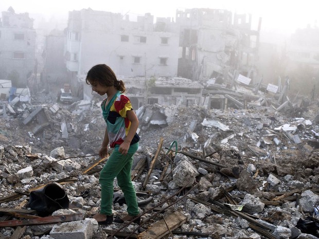 27/8 - Menina vasculha escombros no local onde ficava sua casa após voltar com a família ao bairro de Shejaiya, na Cidade de Gaza (Foto: Roberto Schmidt/AFP)