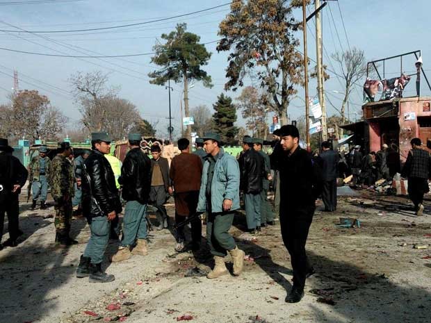 Policiais afegãos e civis inspecionam o local de um ataque suicida no Afeganistão. (Foto: AP Photo)