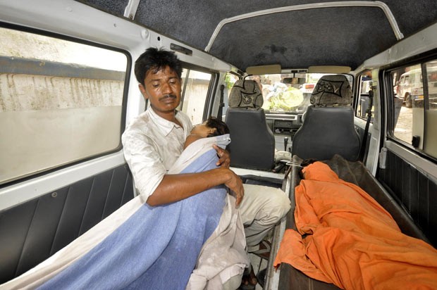 Pai leva filho intoxicado nos braços para hospital na cidade indiana de Patna nesta quarta-feira (17) (Foto: Reuters/Stringer) Pai leva filho intoxicado nos braços para hospital na cidade indiana de Patna nesta quarta-feira (17) (Foto: Reuters/Stringer)