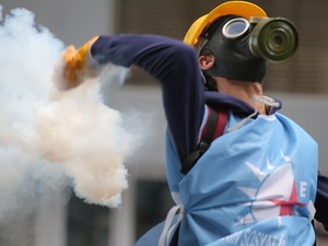 Manifestante atira bomba de gás durante protesto em Istambul, na Turquia (Foto: Emrah Gurel/AP)