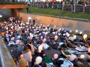 Em Santa Maria, moradores deitaram no asfalto segurando balões rosas em protesto contra a CPI da Kiss. (Foto: Bruna Taschetto/RBS TV)