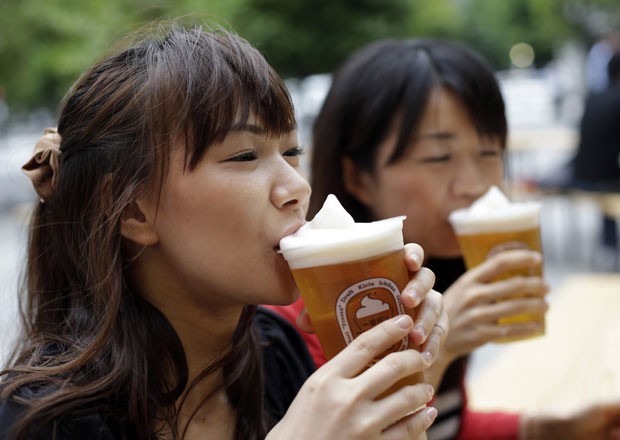 Em foto desta terça-feira (5), garotas apreciam cerveja com espuma congelada Em Tóquio. (Foto: Toru Hanai/Reuters)