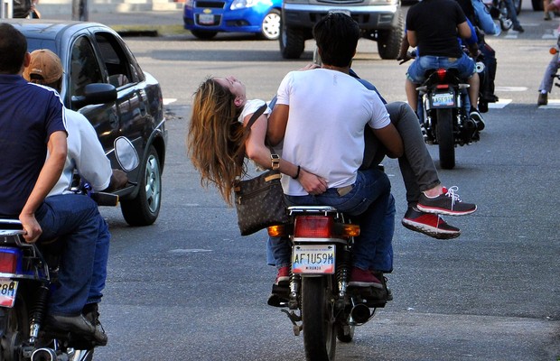 A modelo e estudante Génesis Carmona é levada em uma moto ao hospital em Valencia, Venezuela. Eleita miss em 2013, ela foi baleada durante manifestação contra o governo do presidente Nicolás Maduro (Foto: AP Photo/Diario Notitarde, Mauricio Centeno)