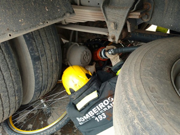 Bombeiros retiram ciclista debaixo de caminhão, no Anel Rodoviário de Montes Claros. (Foto: Divulgação Corpo de Bombeiros)