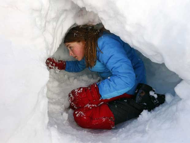 Jovem cava uma ‘toca’ sob a neve que caiu em Maplewood, Nova Jersey. (Foto: Rich Schultz / AP Photo)