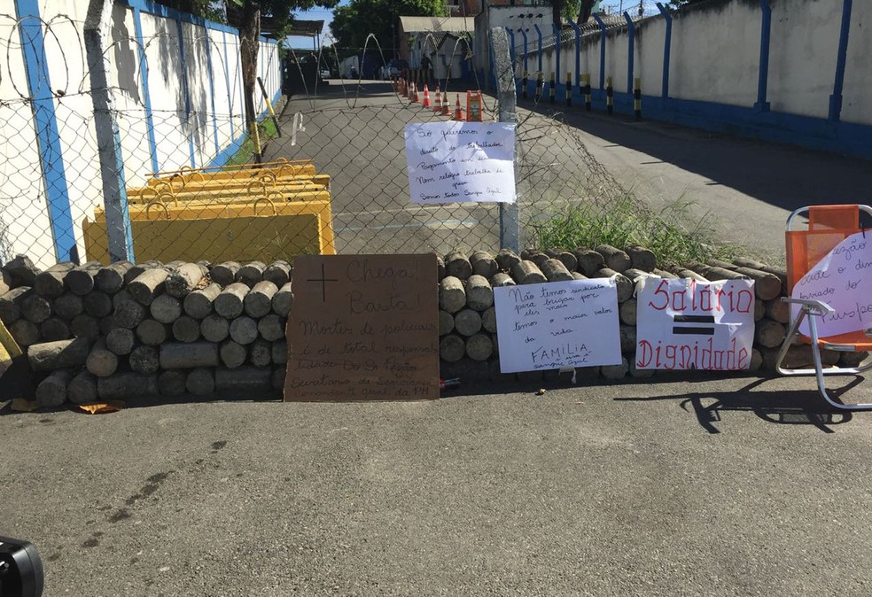 Familiares de policiais colocam cartazes na entrada do Comando de Polícia Pacificadora  (Foto: Cristina Boeckel / G1)