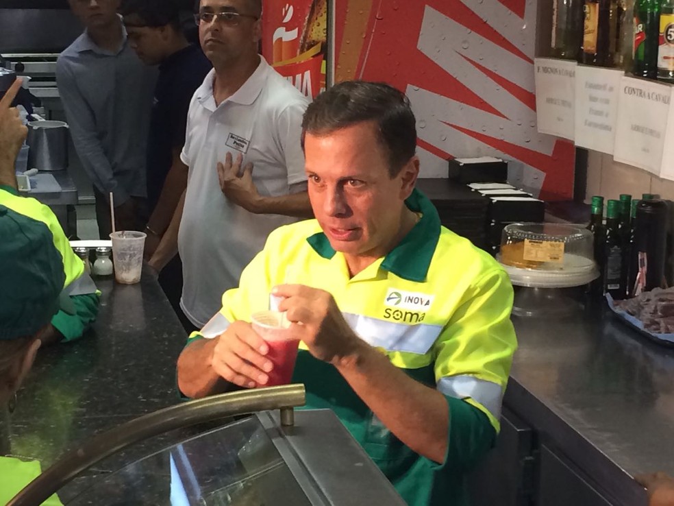 Doria toma suco após varrer a rua (Foto: Roney Domingos/G1)