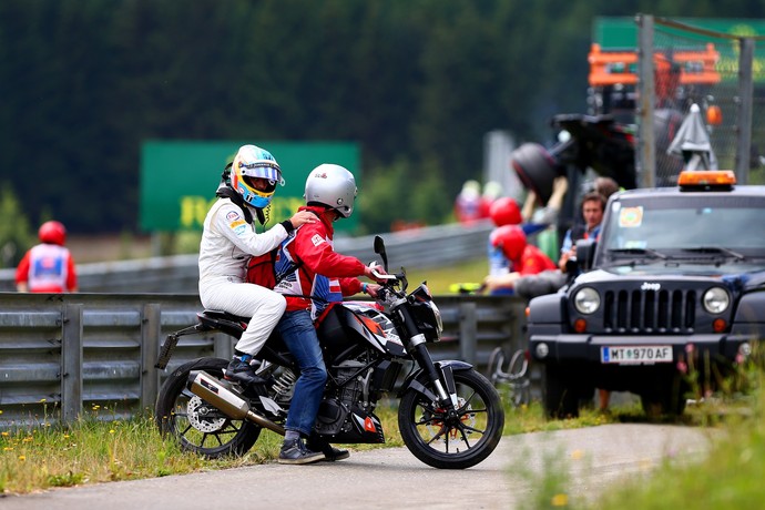 Alonso volta para os boxes de carona na moto de um dos fiscais (Foto: Getty Images)