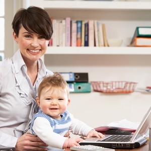 Mãe trabalhando em casa com o bebê (Foto: Shutterstock)