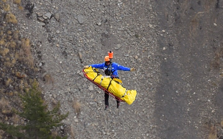 Membro da equipe de investigação da queda do Airbus A320 da Germanwings é içado por um helicóptero perto do local do acidente na cidade de Seyne, nos alpes franceses. O voo 4U9525 ia de Barcelona a Düsseldorf com 150 pessoas a bordo