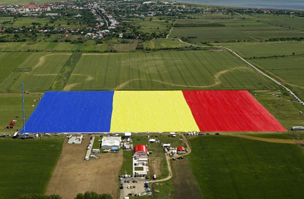 Bandeira gigante é vista do alto em campo na Romênia. Flâmula de 398 m entrou para o Guinness como a maior do mundo (Foto: Bogdan Cristel, Pool/AP)