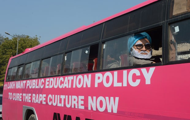 Homem vestido como o premiê indiano Manmohan Singh anda no 'ônibus rosa', que participa de campanha pela educação contra o estupro, nesta quinta-feira (24) em Nova Déli (Foto: AP)