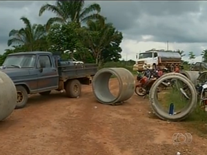 Manilhas foram colocadas para impedir tráfego de veículos de laticínios (Foto: Reprodução/TV Anhanguera)