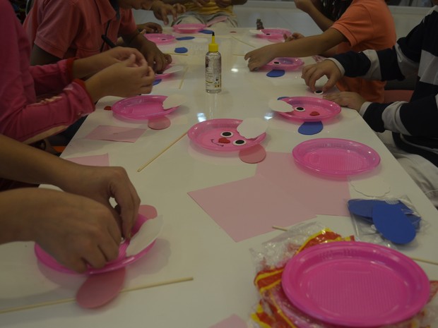 Crianças utilizam objetos como pratos de plástico para fazer brinquedos (Foto: Gabriel Dias/G1)