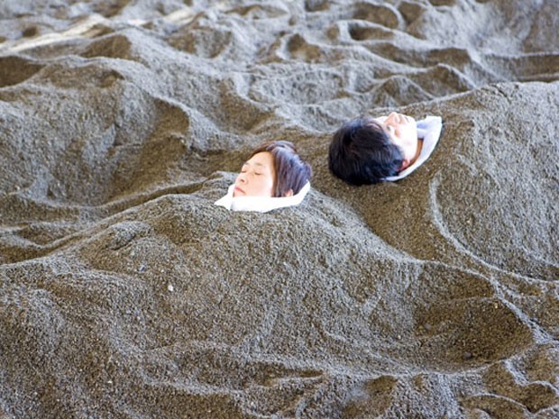 Pessoas são enterradas em areia vulcânica de Ibusuki, no Japão (Foto: Sylvain Grandadam/Getty Images)