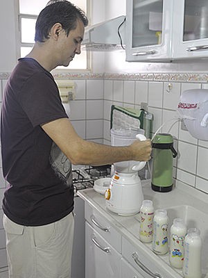É Renato quem levanta todos os dias para preparar as quatro mamadeiras (Foto: Denise Soares / G1)