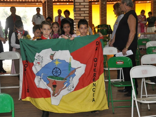 Crianças levam bandeira do Rio Grande do Sul para dar início a missa (Foto: Aliny Mary Dias/G1 MS)