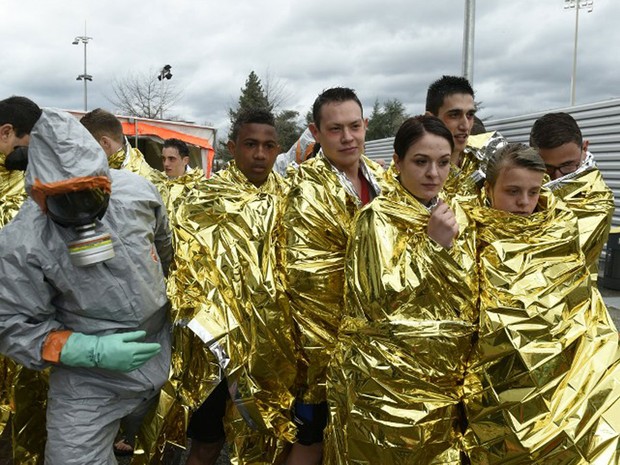 Bombeiros usam roupa de proteção para atender ‘vítimas’ de ataque químico em exercício no Geoffroy Guichard, em Saint-Etienne, nesta segunda-feira (4) (Foto: Philippe Desmazes / AFP)