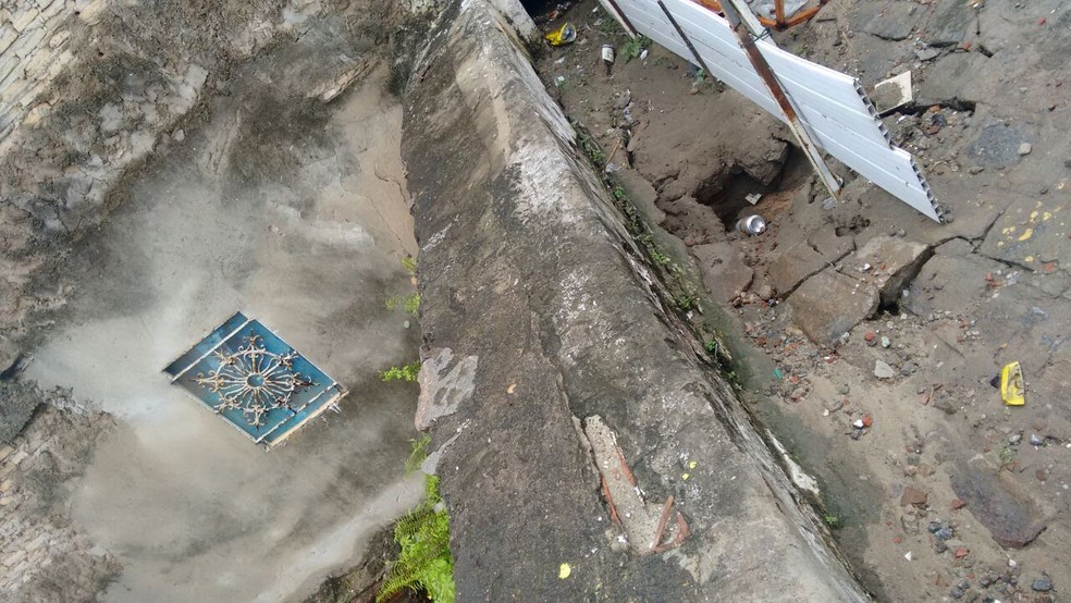 Buraco aberto pela chuva abalou estrutura de oficina, que pode desmoronar sobre casas abaixo (Foto: Divulgação/Defesa Civil )